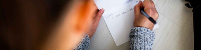woman writing a letter or greeting card to a friend